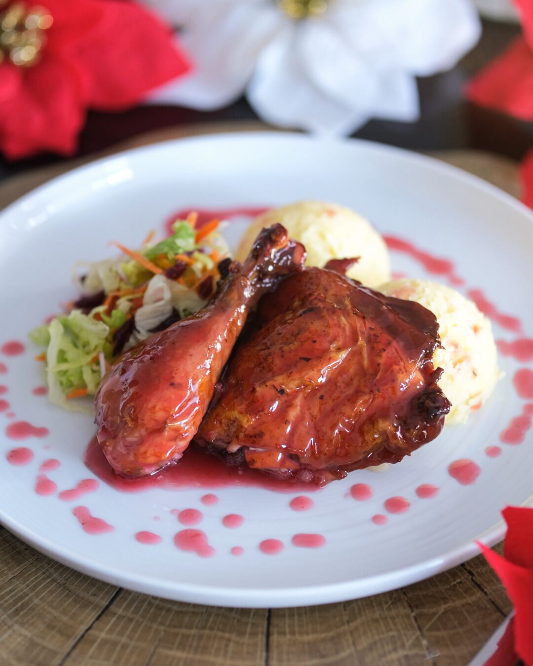 A plate with roasted chicken, mashed potatoes, and a side salad.