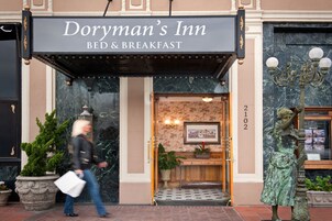 Doryman's Inn, med en skylt som visar att det är ett bed and breakfast, en entré i marmor, en staty och nummer 2102 på väggen.