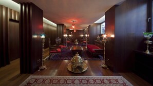 A spacious hallway with a central ornate table, seating area, and ambient lighting. - Burckin Hotel (Istanbul)