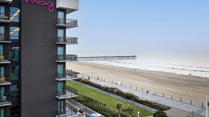 Un hotel moderno con balcón y vistas a la playa y al muelle.
