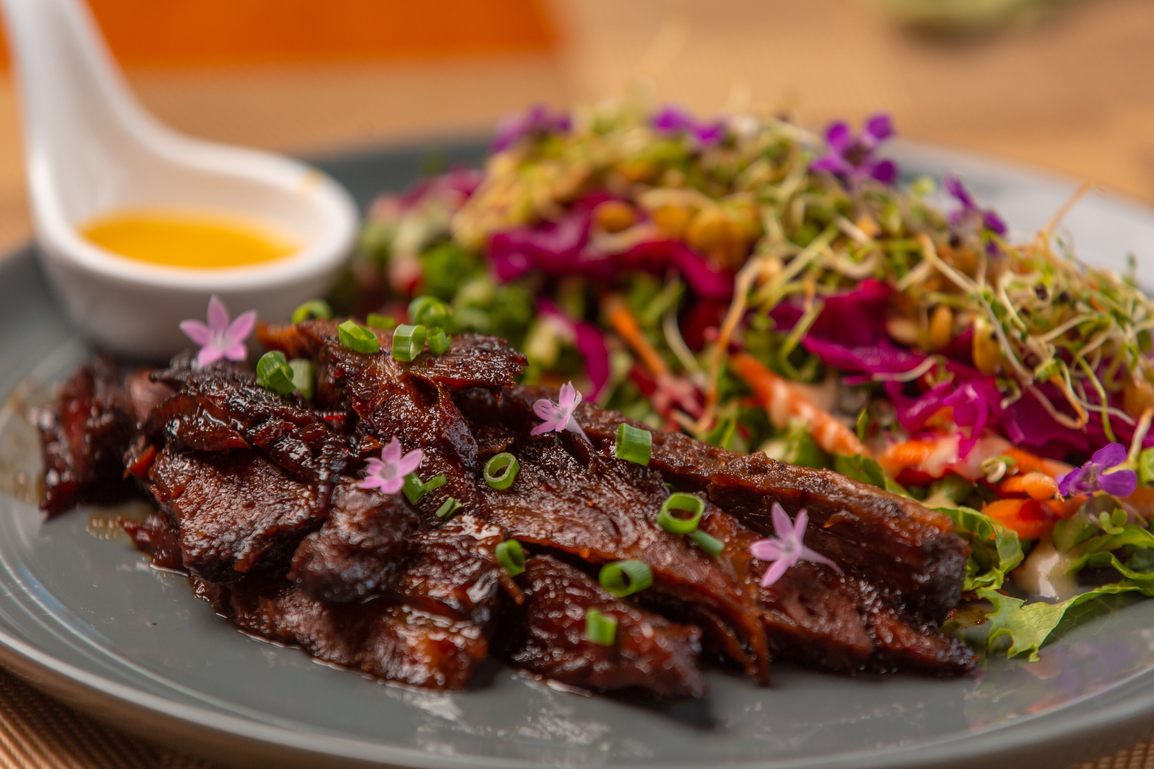 A plate of food with meat and a side salad.