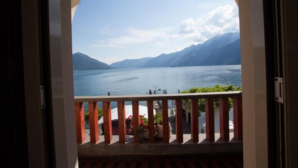 A balcony with a view of a lake and mountains. - Piazza Ascona Hotel & Restaurants (Ascona)