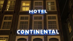 Un hotel llamado "Continental" con una fachada clásica de ladrillo y múltiples ventanas.