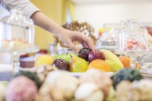A variety of fruits on a buffet table, including apples, bananas, and oranges. - Strandhotel Alte Donau (Vienna)