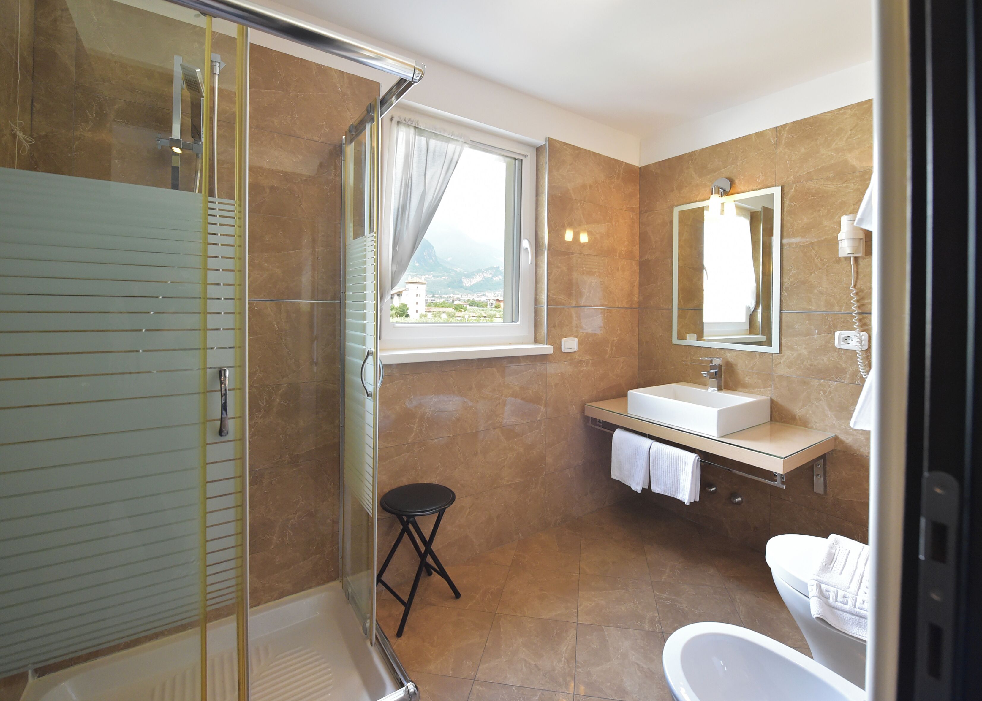 Ein modernes Badezimmer mit Duschkabine, Waschbecken mit Spiegel und Toilette.