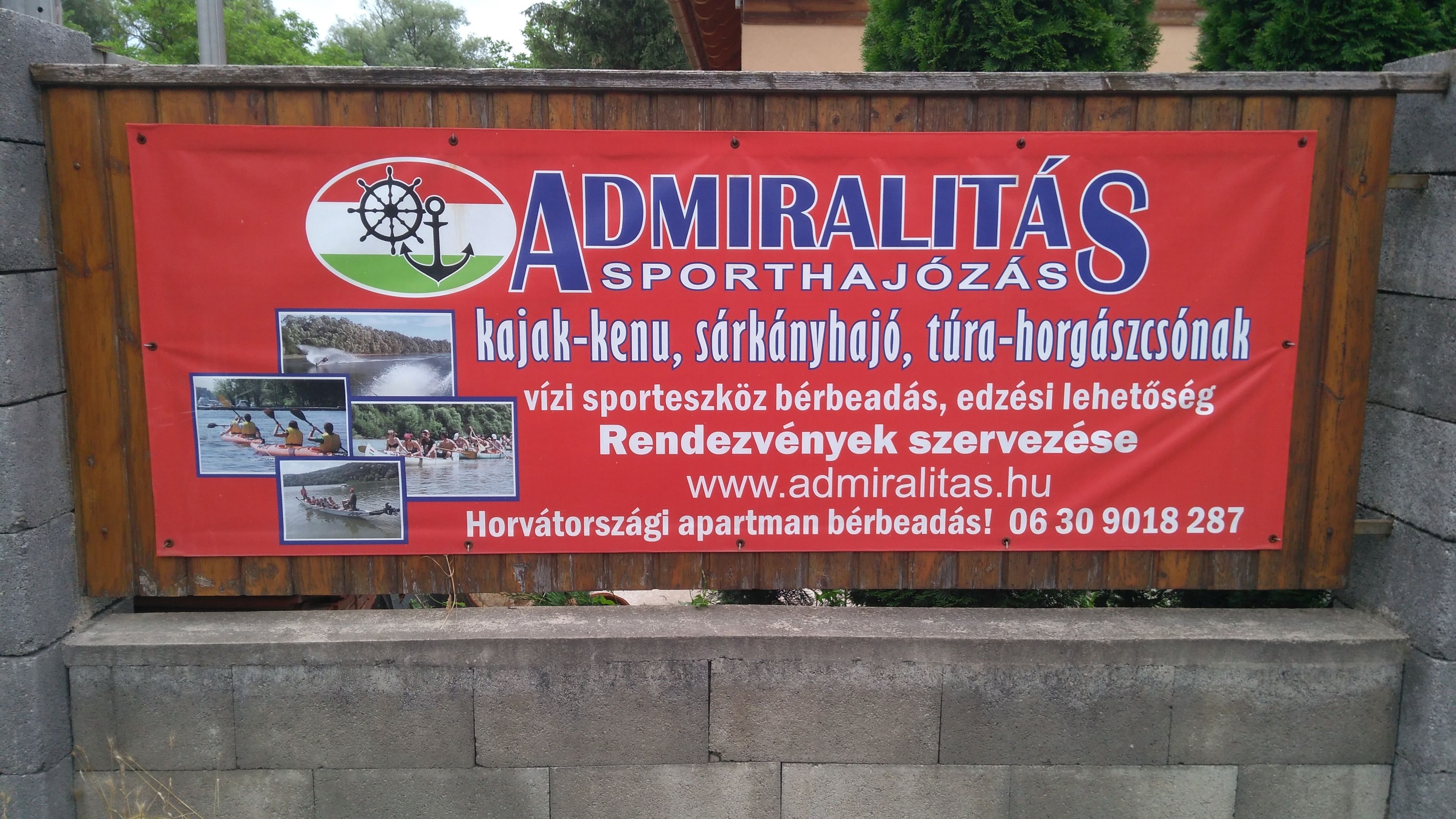 A red signboard advertising sports facilities including kayaking, sailing, and canoeing.