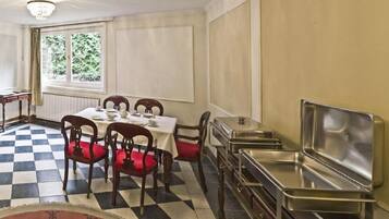 A dining area with a checkered floor, a table set for four, and a buffet station.