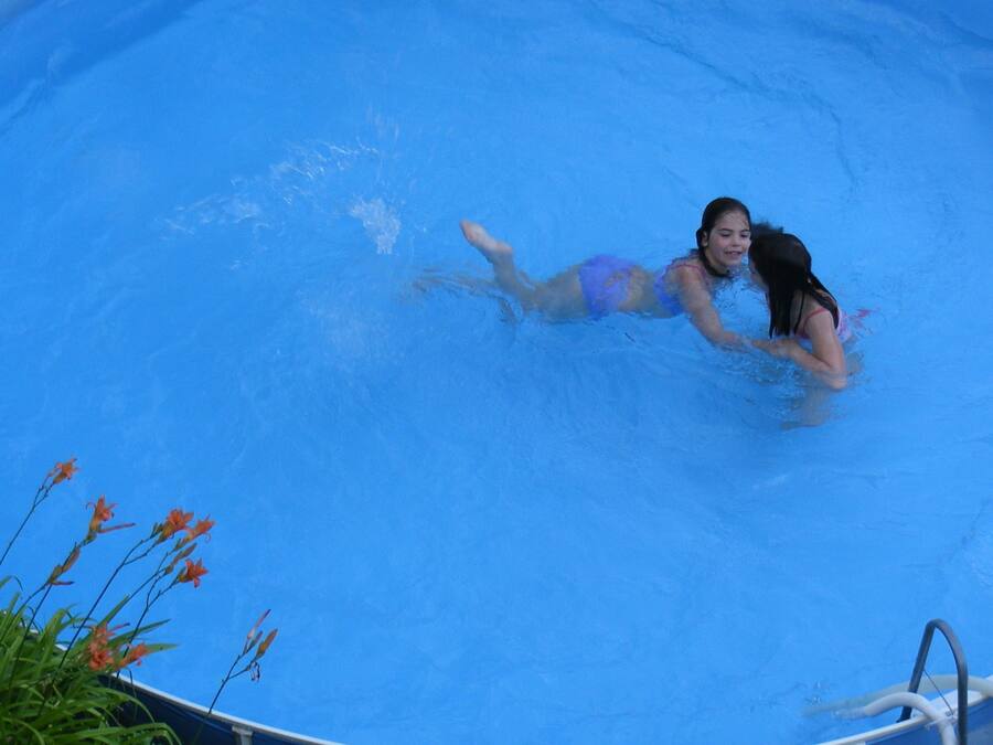Une personne nage dans une piscine bleue.