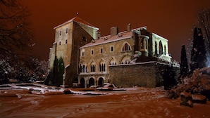 Un edificio histórico con múltiples arcos y una torre, rodeado de nieve.