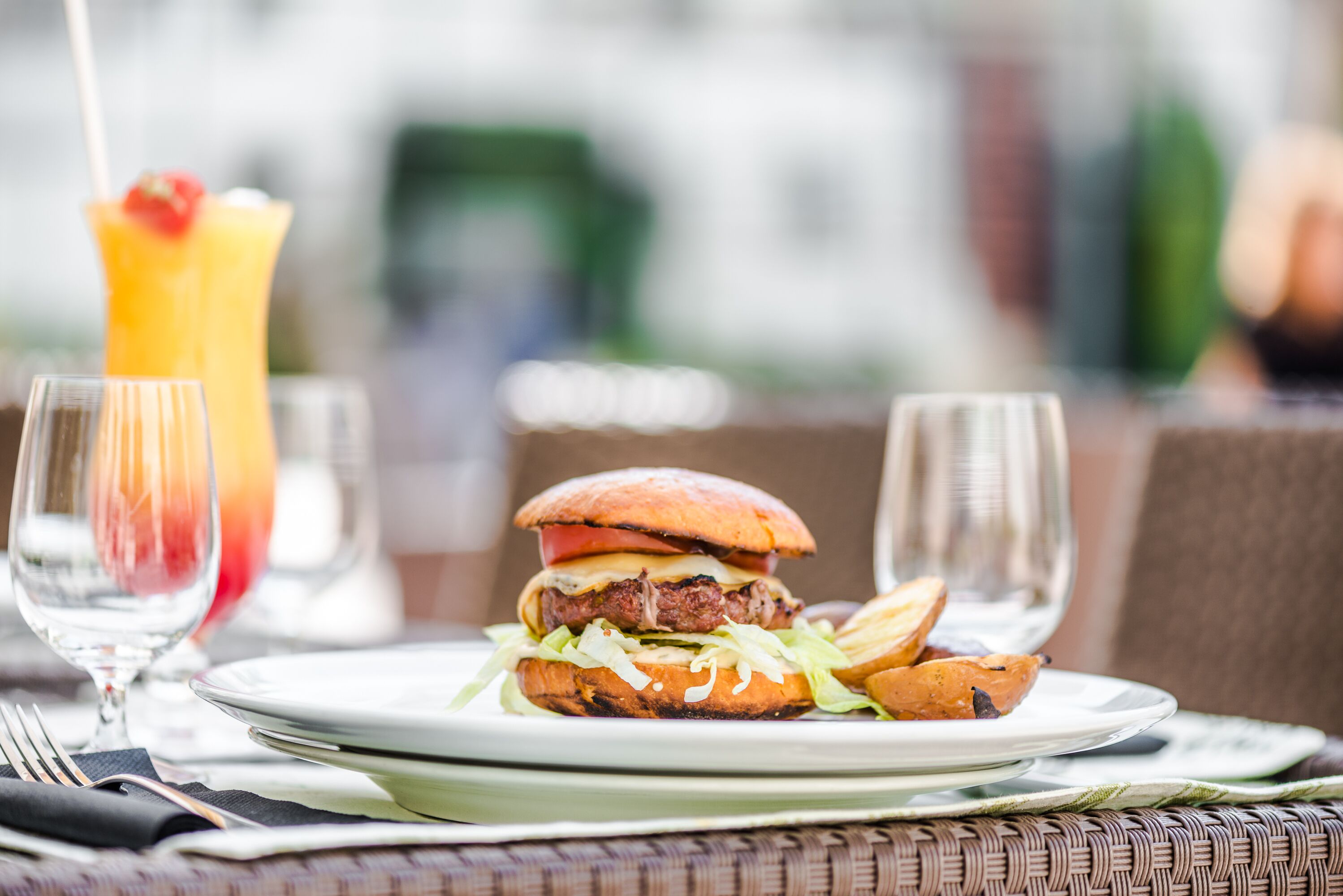A meal with a burger, fries, and a drink on a table.