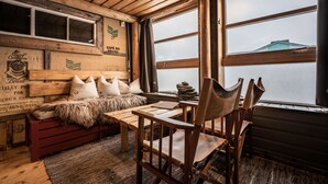 L’intérieur d’un chalet accueillant, avec un banc en bois, une table et des chaises.