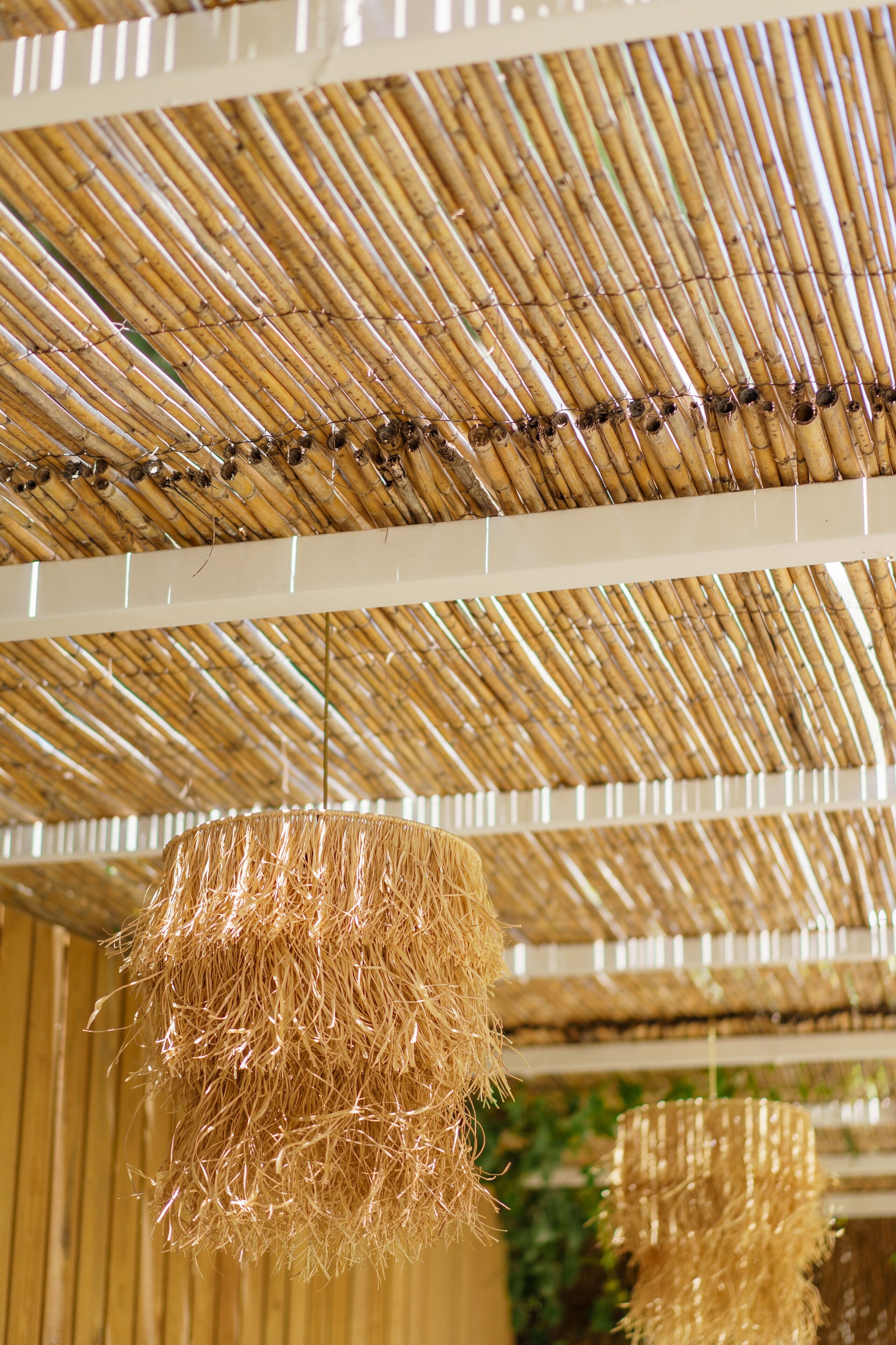 A ceiling with a bamboo pattern and hanging rattan decorations.