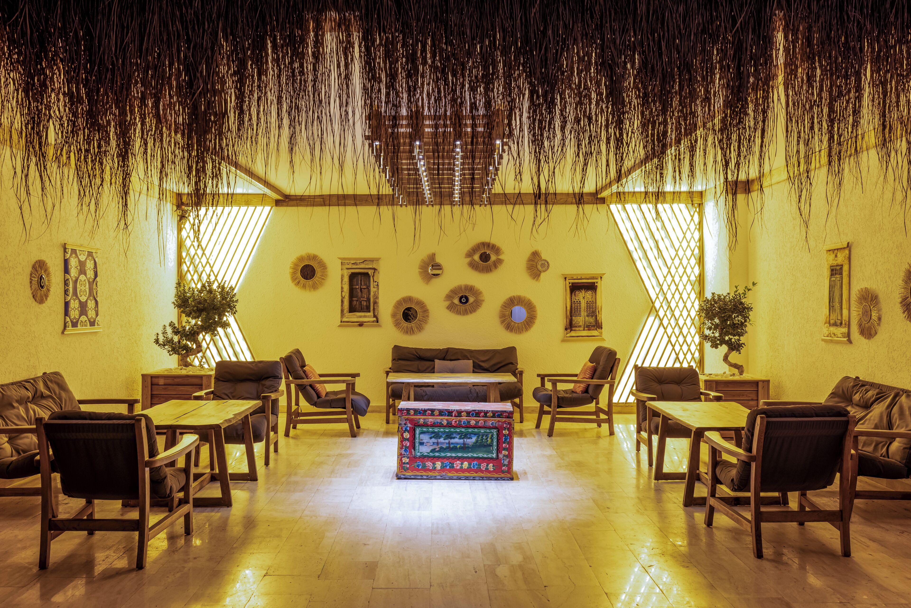A spacious lobby with a central coffee table, multiple seating areas, and decorative wall elements.