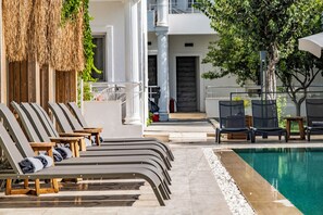 Una piscina al aire libre de temporada, sombrillas