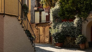 Una estrecha calle adoquinada con una escalera que lleva a un edificio con un letrero que dice "Grotto Baldoria".