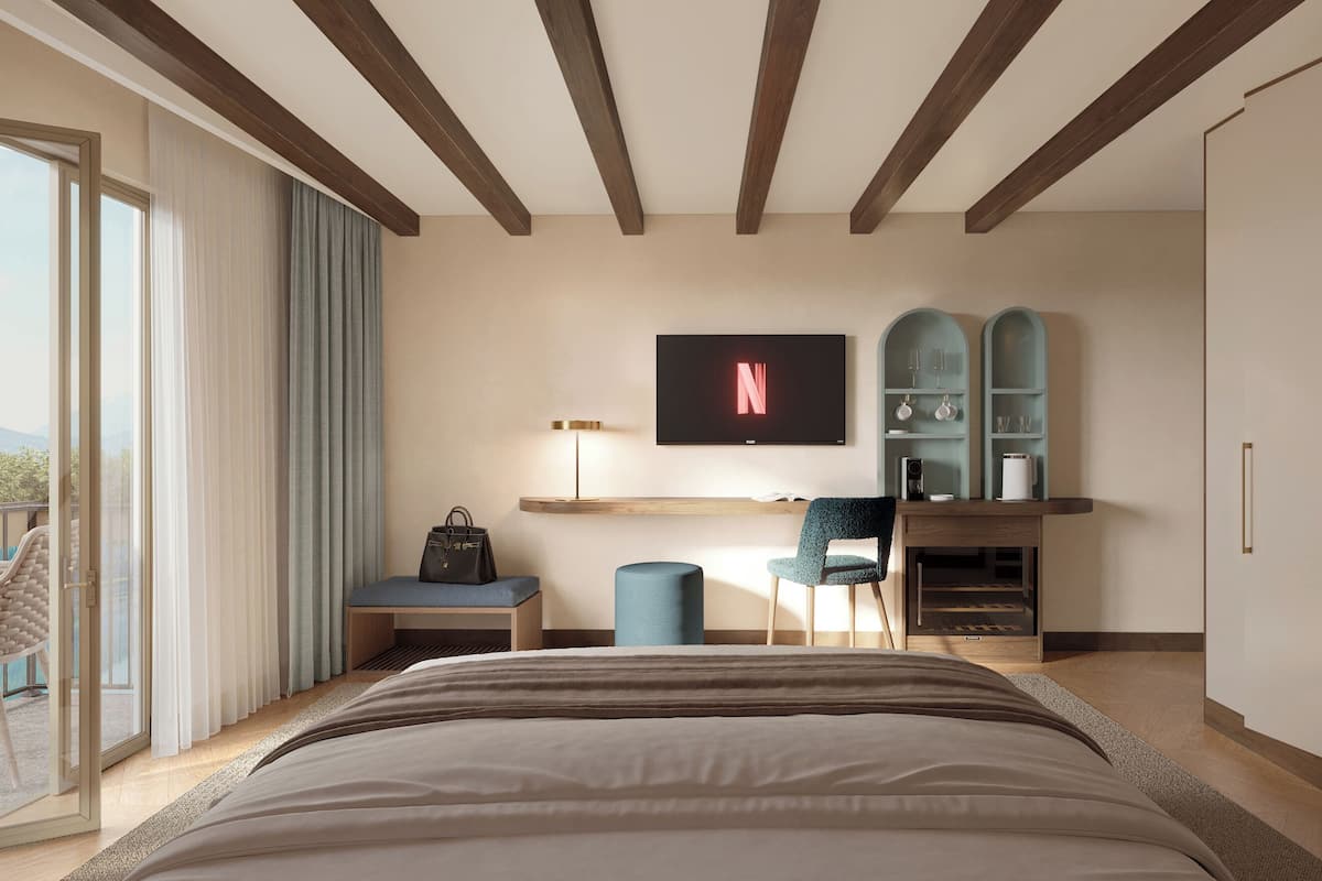 Un dormitorio moderno con una cama grande, un escritorio con televisor, una silla y un armario.