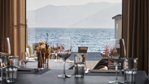 Una mesa lista para comer con vista al mar y a las montañas.