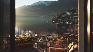 Un balcón con vista a un lago, montañas y un pueblo.