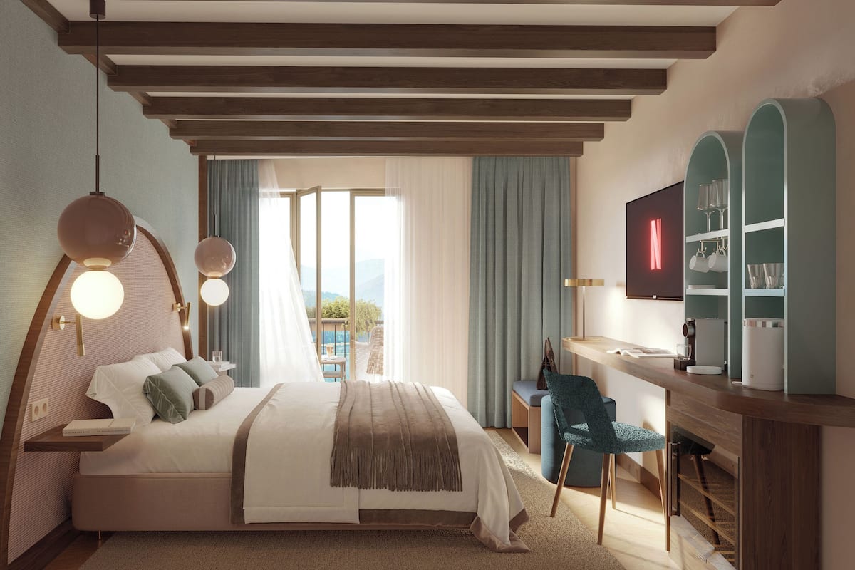 Un dormitorio moderno con una cama grande, mesitas de noche, un escritorio y un televisor.