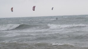 Vista del océano con olas y una persona practicando surf.