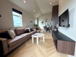 Una sala de estar moderna con un sofá, una mesa de centro y un comedor con sillas.