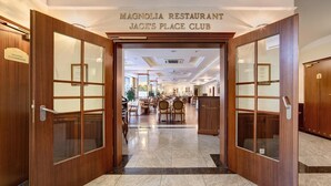 The entrance to Magnolia Restaurant Jack's Place Club with a spacious dining area visible through the glass doors. - Hotel Prezydent (Krynica-Zdroj)