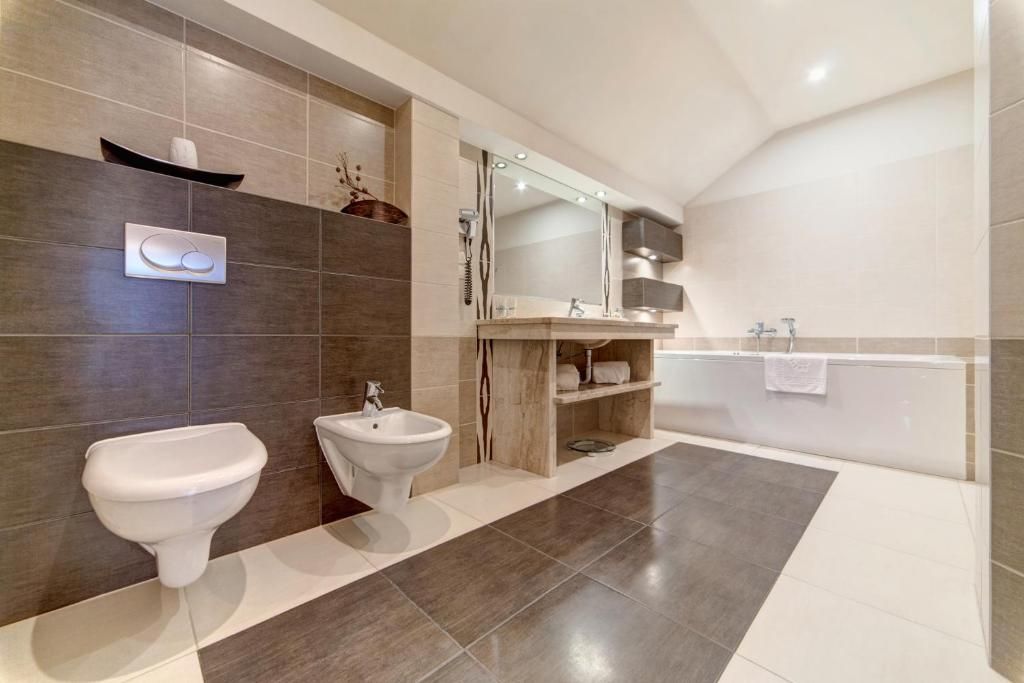 Un baño moderno con bidé, lavamanos y bañera.