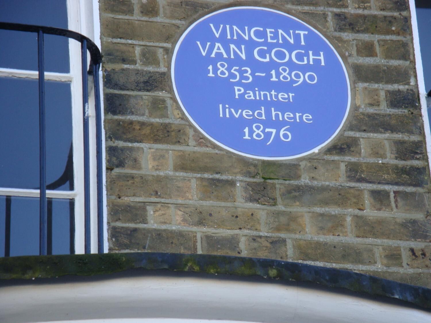 A blue plaque on a brick wall stating "Vincent Van Gogh 1853-1890 Painter lived here 1876".