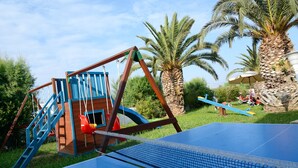 A playground with a swing set and a seesaw. - Aslanis Village Hotel (Kos)