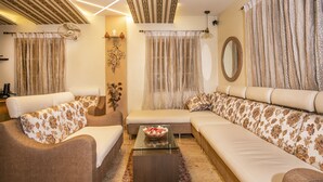 A living room with a sofa set, a coffee table, and a decorative wall piece. - Aishwarya Residency (Mysore)