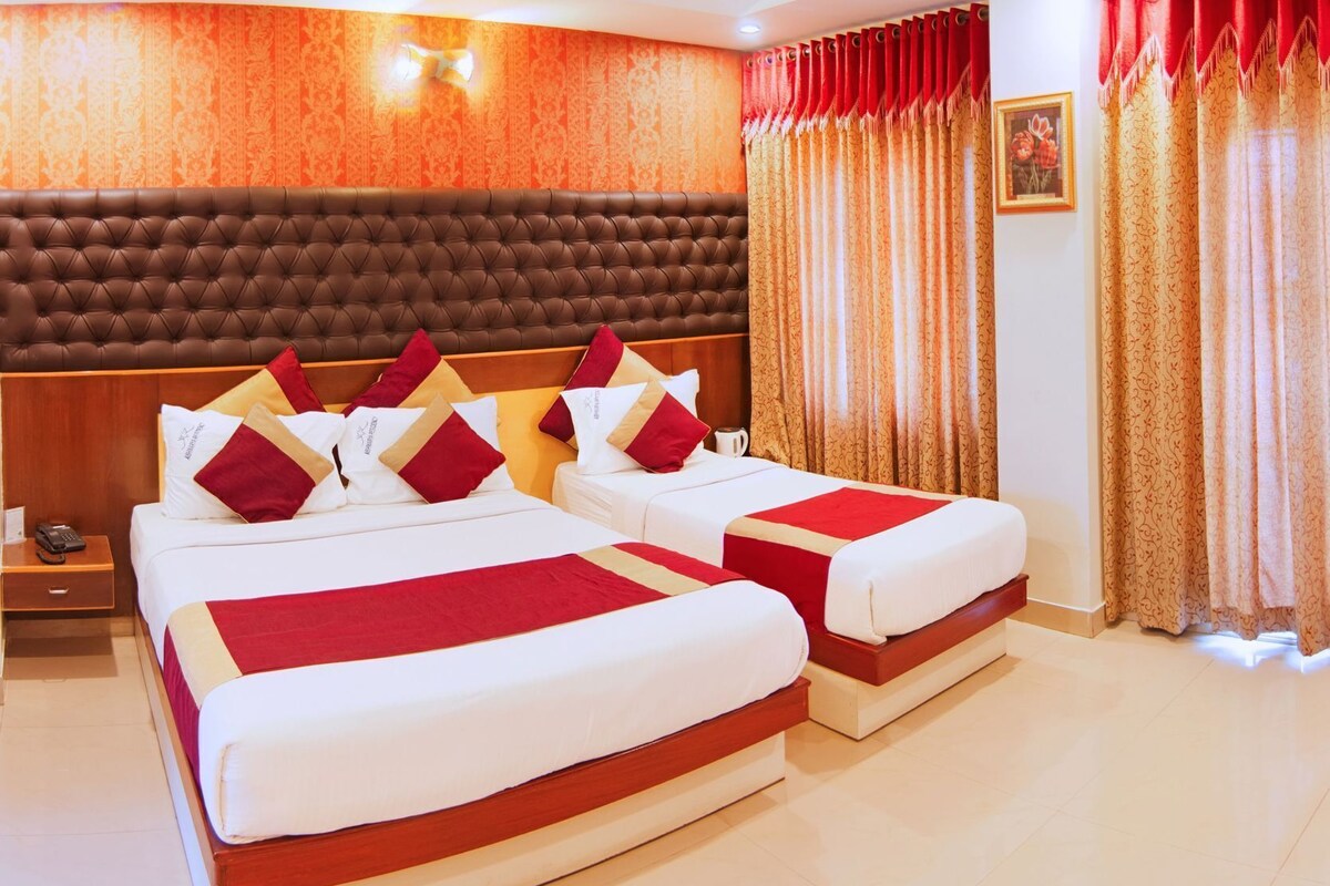 A hotel room with two beds, a wooden headboard, and a red and white color scheme.