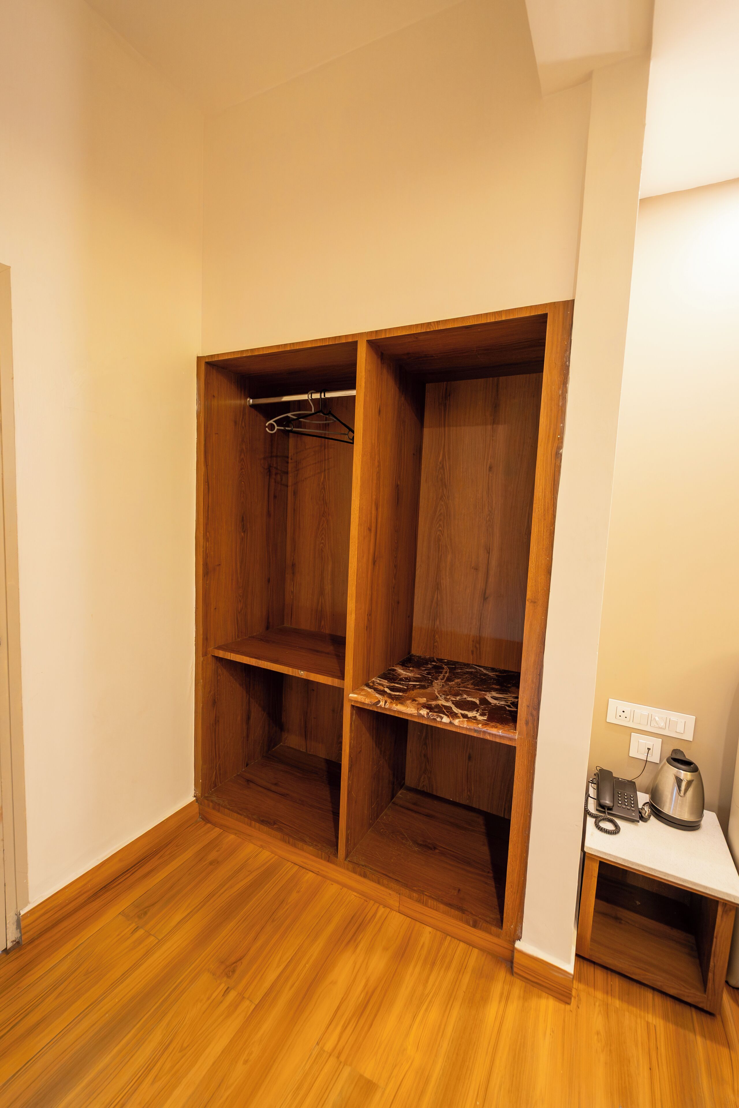 A walk-in closet with wooden shelving and a hanging rod.