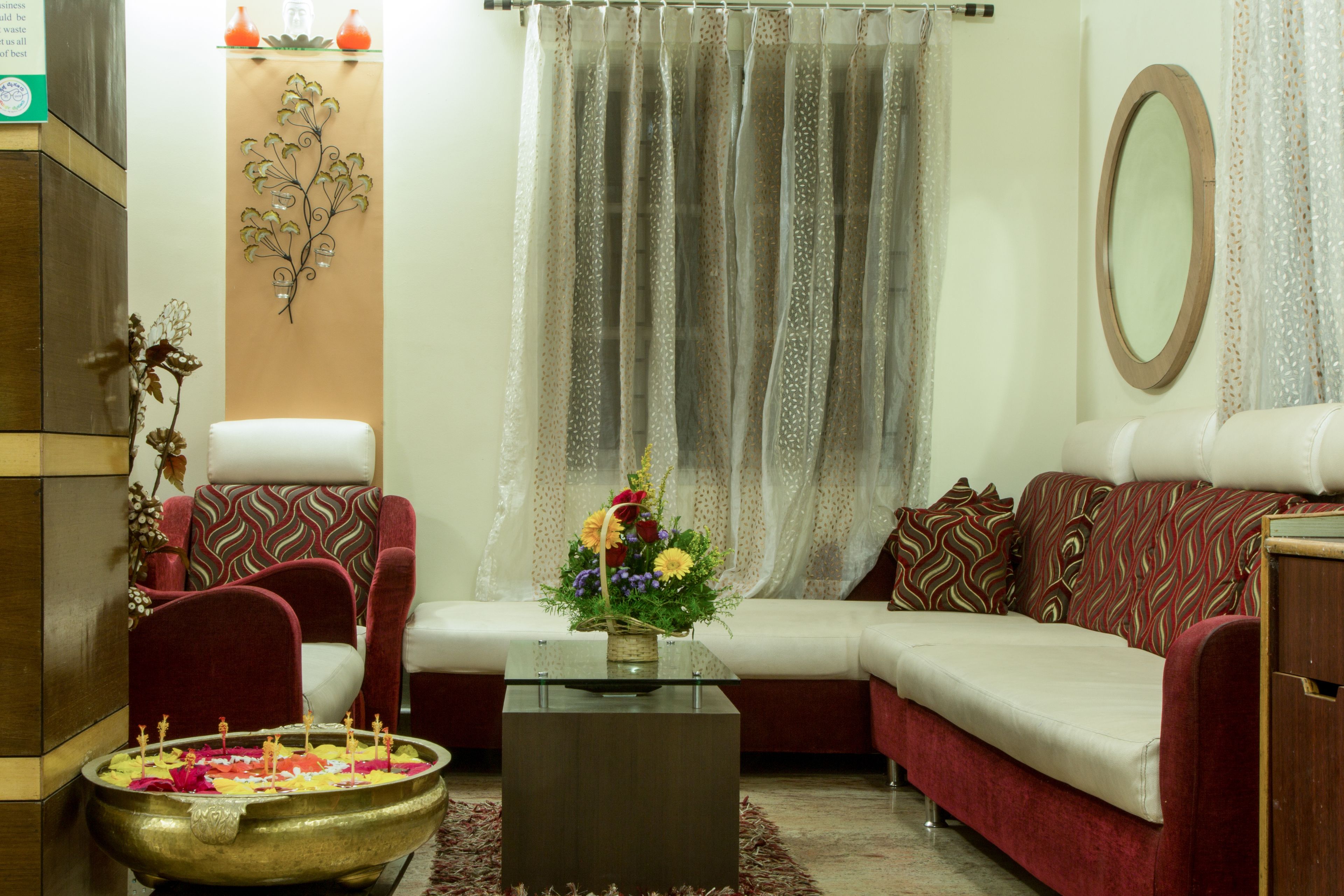 Un salón con sofá, sillones, una mesa de centro y un jarrón decorativo.