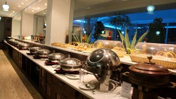 Una barra de buffet con diversos alimentos y recipientes.