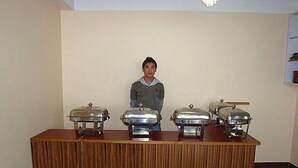 A buffet setup with three covered food containers on a wooden counter. - Hotel Royal Residency (Gangtok)
