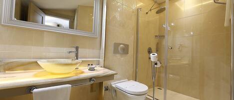 A modern bathroom with a glass-enclosed shower, a sink with a vessel basin, and a toilet.