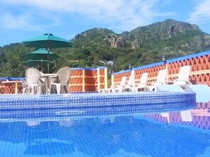 Una piscina al aire libre, sombrillas