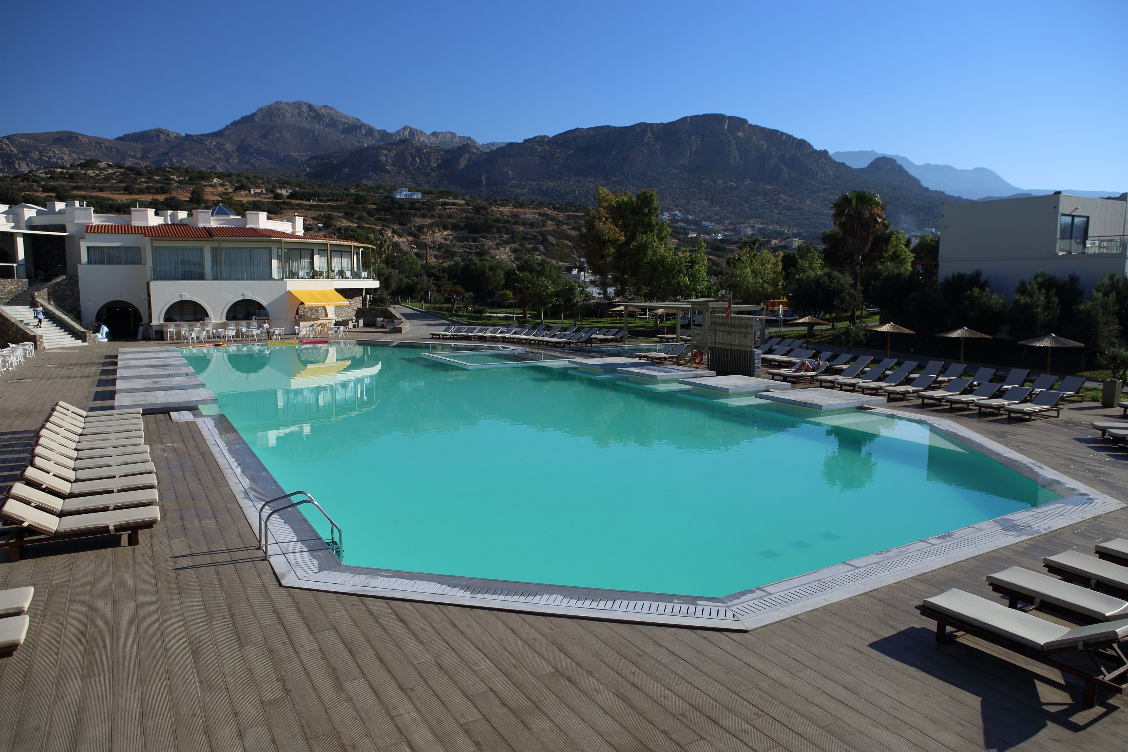 Un espace piscine avec des chaises longues et une vue sur les montagnes.