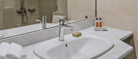 A modern bathroom with a large mirror, a sink, and a shower.
