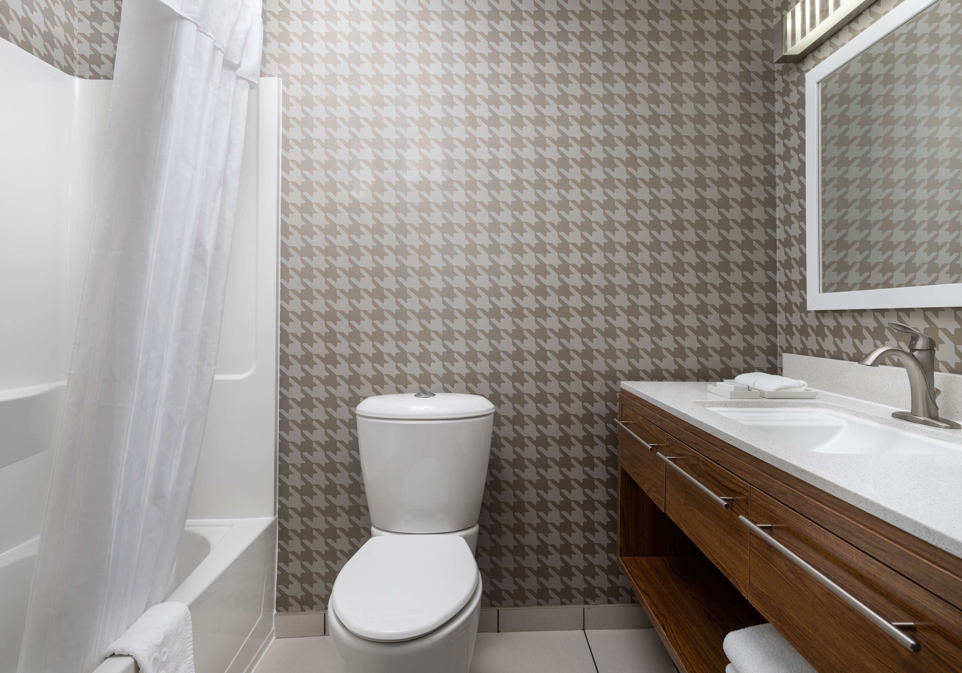A modern bathroom with a shower, toilet, and vanity.