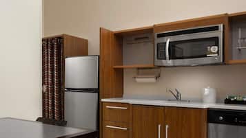 Una cocina compacta equipada con refrigerador, microondas y lavavajillas.