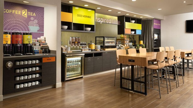 Un café moderne doté d’un comptoir, d’un espace salon et de différents types de machines à café.