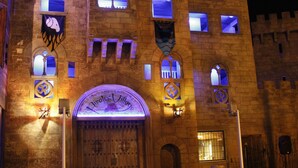 A castle-like building with arched windows and a large wooden door. - Pirates Village (Calvia)