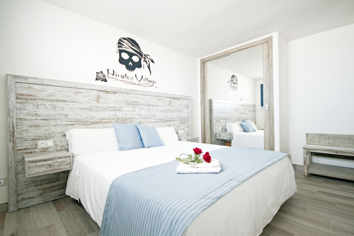 Un dormitorio con una cama grande, un espejo y un logotipo en la pared.