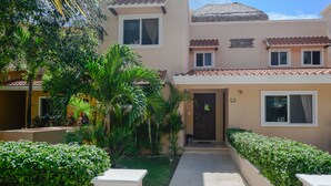 A two-story building with a tiled roof, a small front porch, and a number '52' on the wall. - Villas Picalu Lodge (Puerto Aventuras)