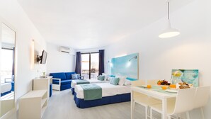 Une chambre d’hôtel moderne avec deux lits, un coin repas et une grande fenêtre avec des rideaux.
