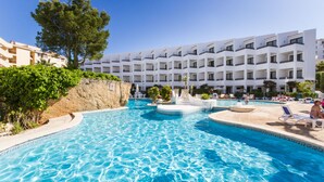Un hôtel doté d’une piscine, de plusieurs balcons et d’un espace paysager agrémenté d’arbres.