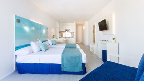 Une chambre d’hôtel moderne dotée d’un grand lit, d’un bureau et d’une kitchenette.