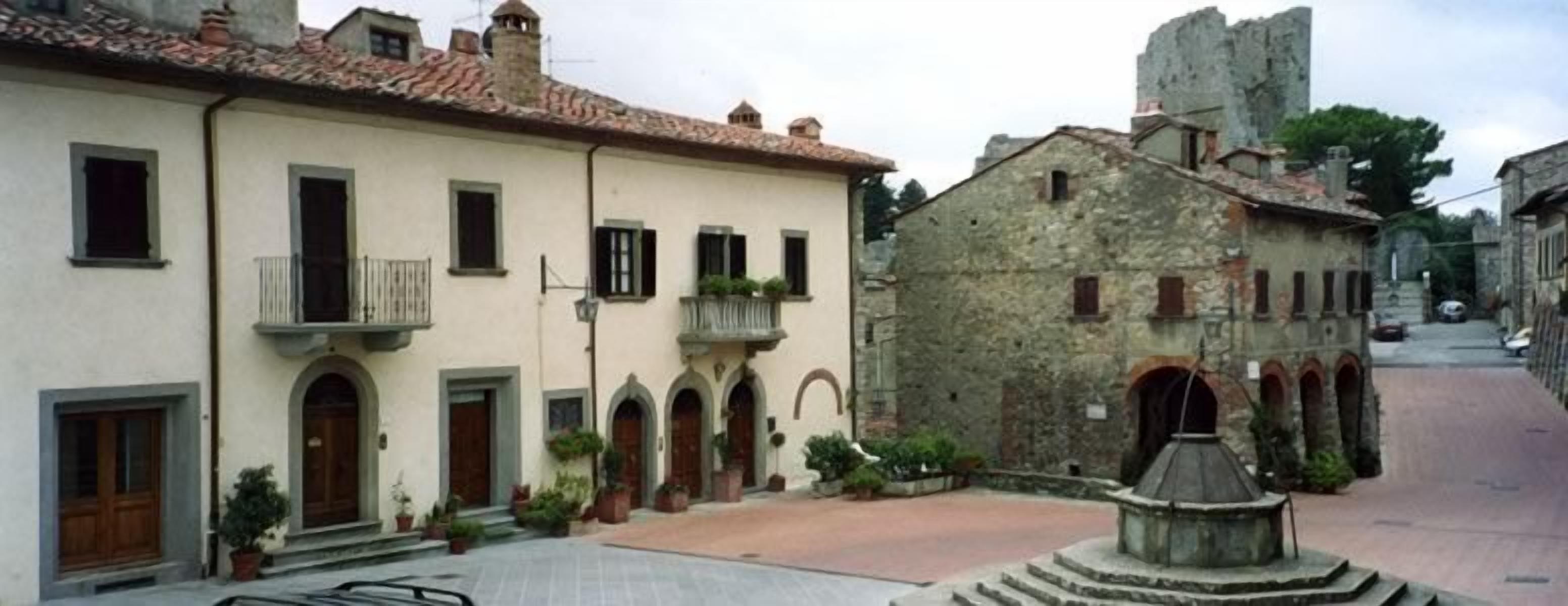 A traditional European street with a building featuring arched windows and a stone facade.