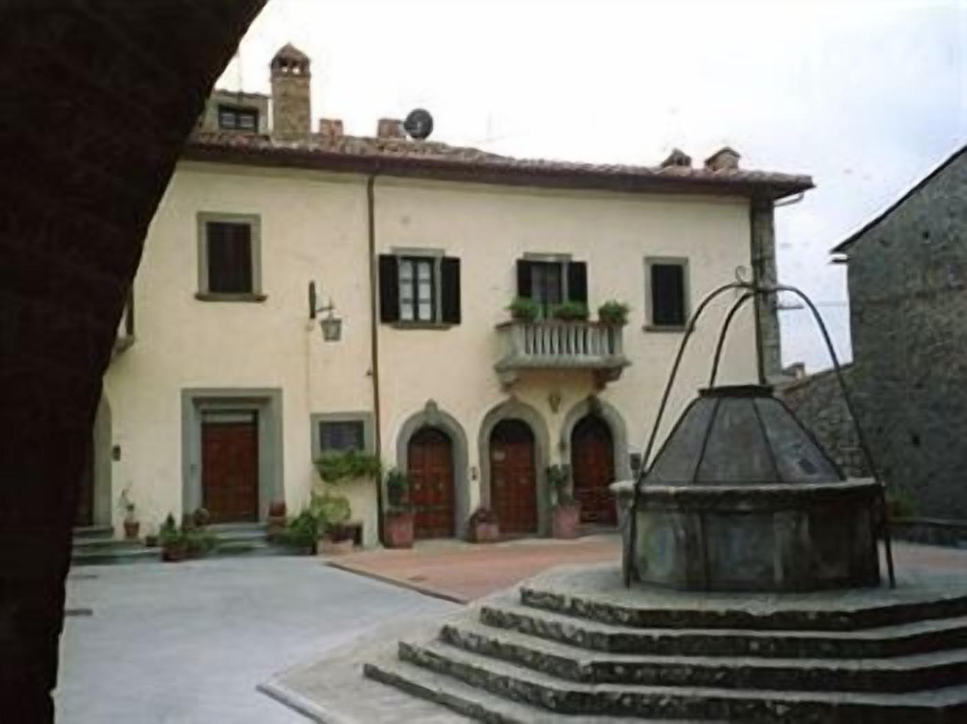 Un edificio con un patio, una fuente y una escalera que conduce a la entrada.